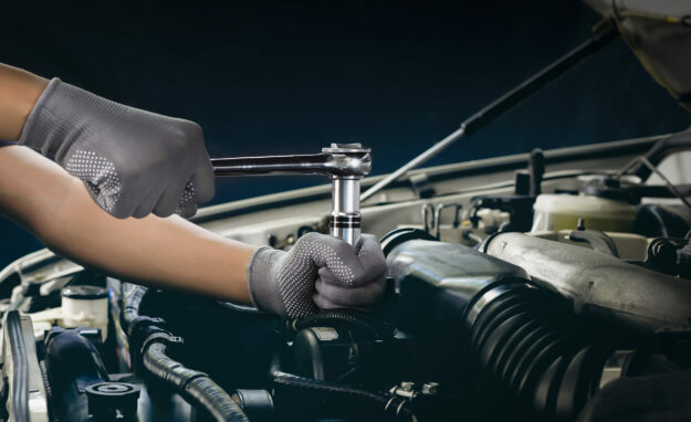 Car mechanic working on car engine, car maintenance concept. Car Mechanic Working On Car Engine, Car Maintenance Concept.