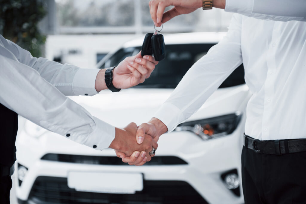 Close Up Of Sales Manager In Black Suit Selling The Car To The Customer