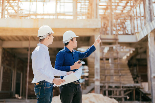 Half-body photo of a team of Asian engineers, 2 males as a manager look and point to the destination use blueprint In design, construction, architecture industry use radio communication wear a helmet Half Body Photo Of A Team Of Asian Engineers, 2 Males As A Manager Look And Point To The Destination Use Blueprint In Design, Construction, Architecture Industry Use Radio Communication Wear A Helmet